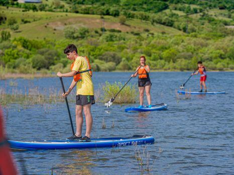 grupo de personas divirtiéndose con las tablas de paddle surf