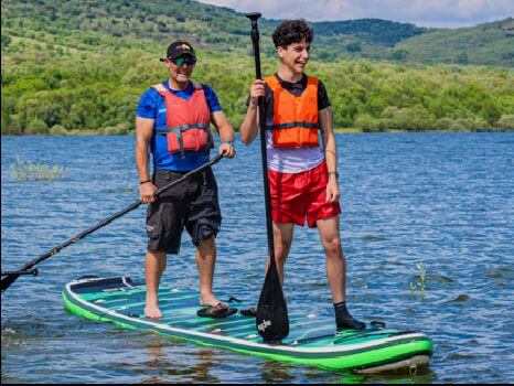 grupo de personas en la iniciación de paddle surf en el embalsde de Pinilla
