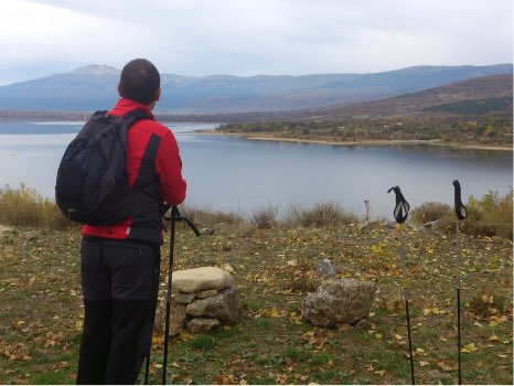 persona admirando las vistas del embalse de Pinilla mientras practica senderismo