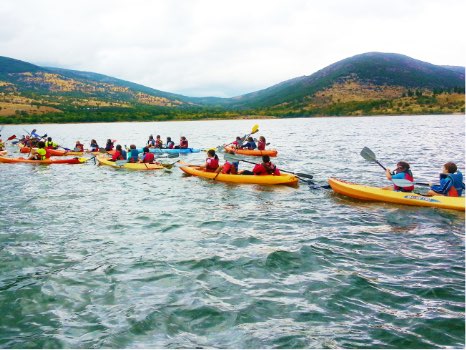 grupo de niños en las piraguas o kayaks triples en el embalse de Pinilla
