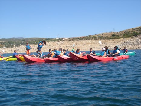 niños jugando con las piraguas y kayaks en El Atazar en Cervera de Buitrago